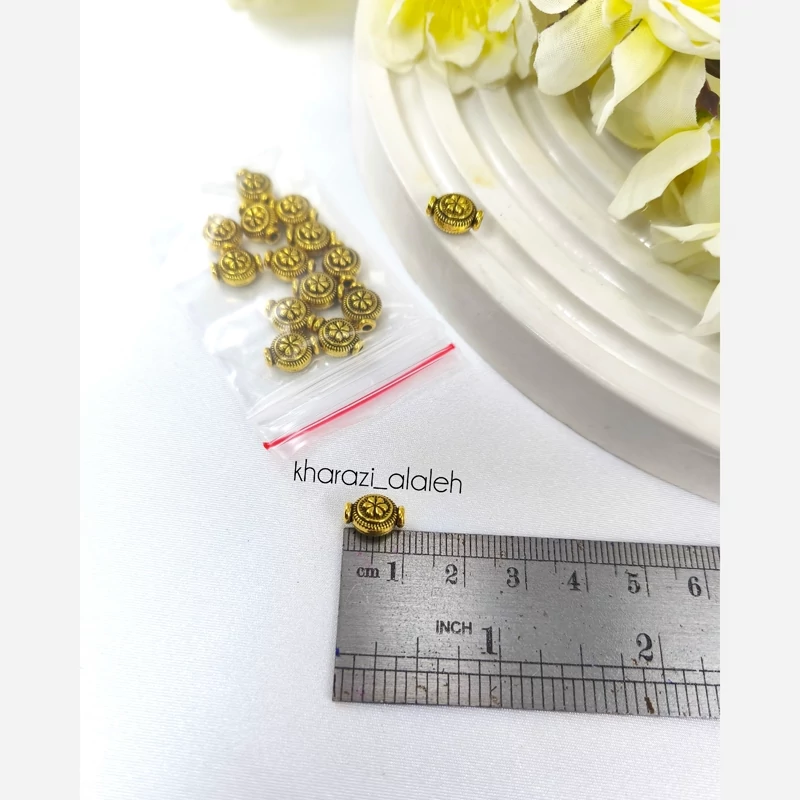 خرجکار بین مهره طلایی طرح گلدان (فروش به صورت بسته ی 15 گرمی و تقریباً 15 عدد)