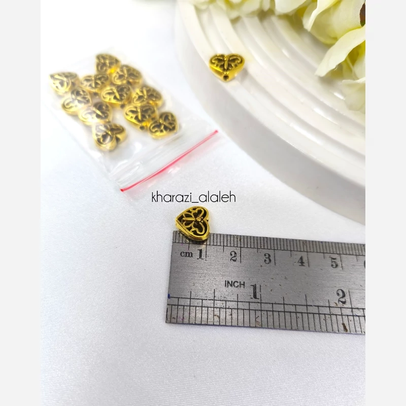 خرجکار بین مهره طلایی طرح قلب پروانه ای (فروش به صورت بسته 15 گرمی و تقریباً 13 عددی)